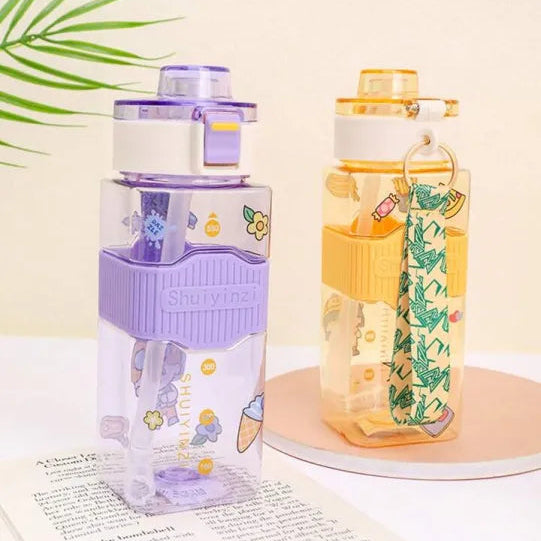 Two water bottles with colorful stickers on a light surface.