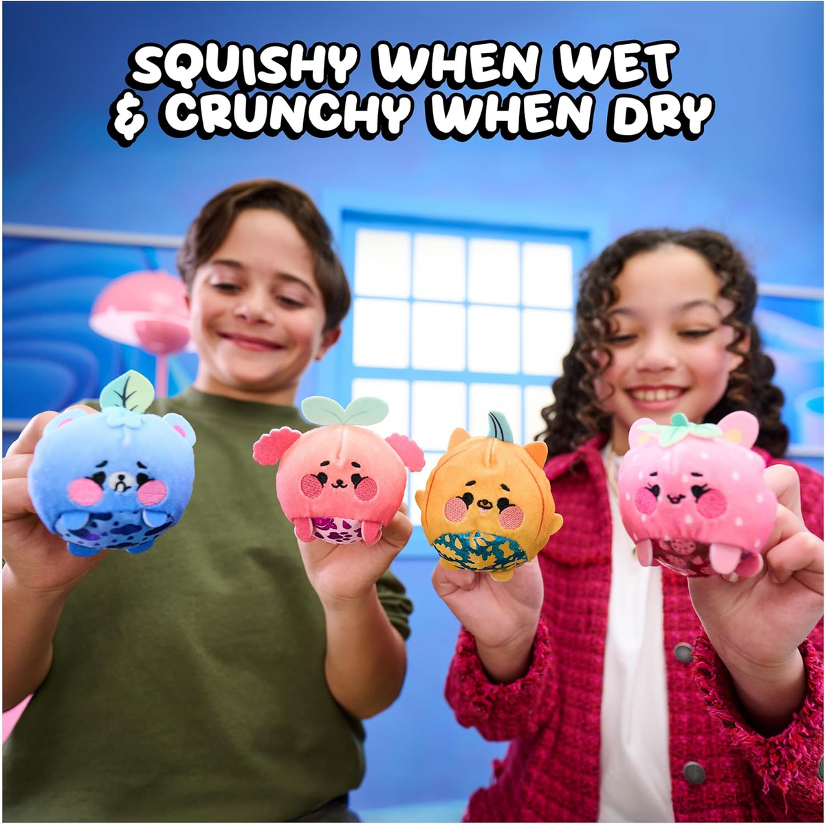 Two children holding colorful squishy toys with text 'Squishy when wet & crunchy when dry' above them.